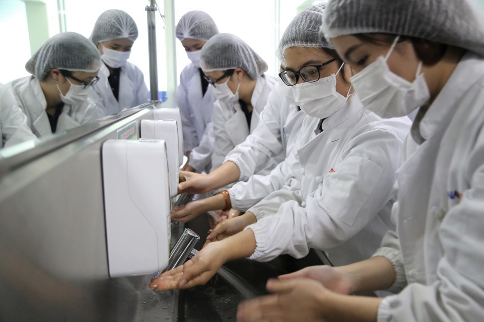 Students prepare protective clothing and sanitize their hands before visiting the airline catering production process.